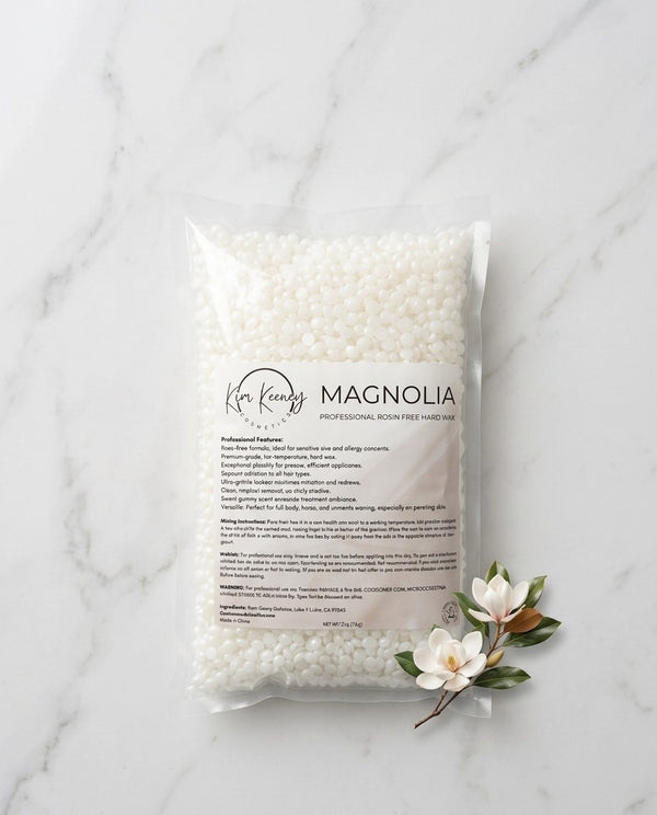 Kem Keeney Esthetics Packaged Hard wax beadst labeled 'Magnolia' on a marble surface with decorative flowers.