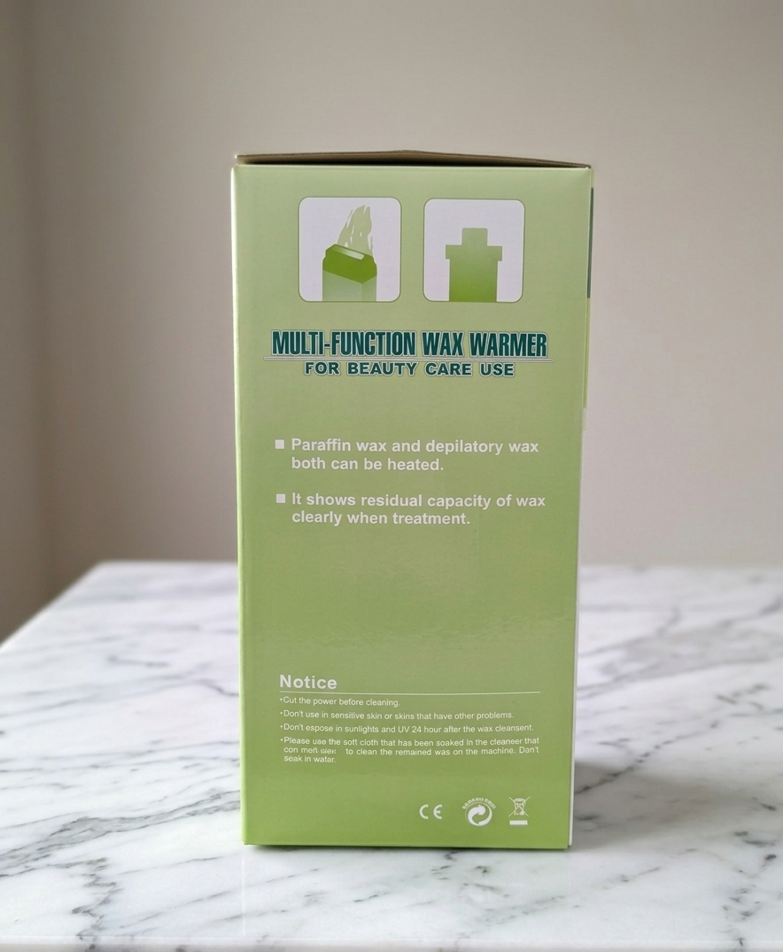 Green box of a multi-function wax warmer on a marble surface